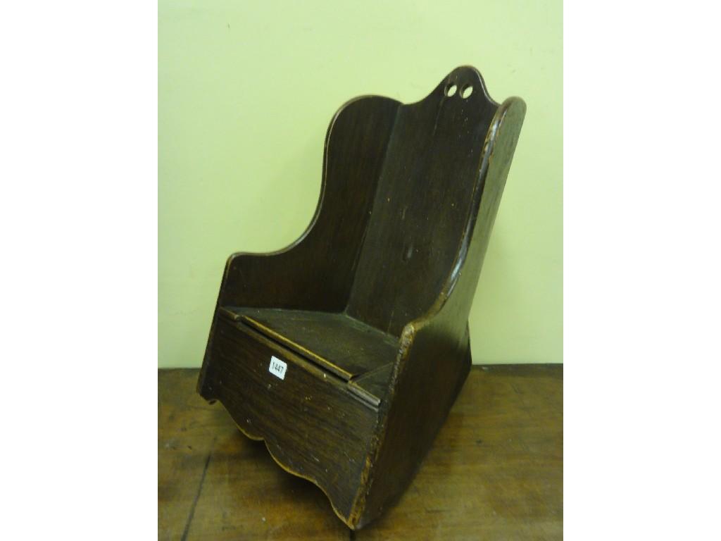 Appraisal: An antique oak child's rocking commode chair with winged back