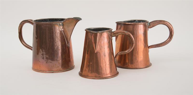 Appraisal: THREE ENGLISH COPPER GRADUATED PITCHERS Of flared cylindrical form one