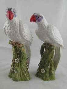 Appraisal: A pair of ceramic white parrots each on a tree