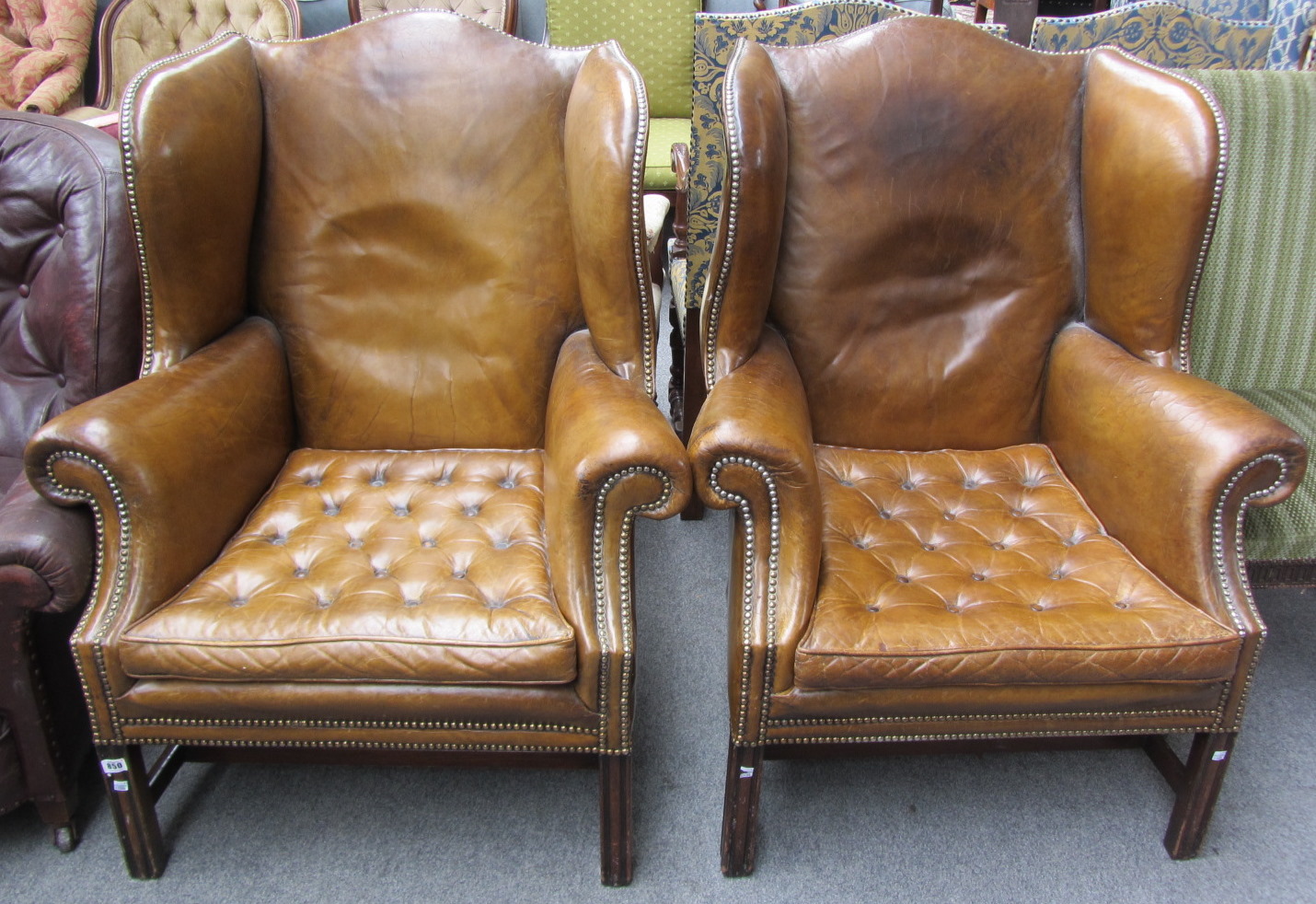 Appraisal: A pair of brass studded leather wingback armchairs of th