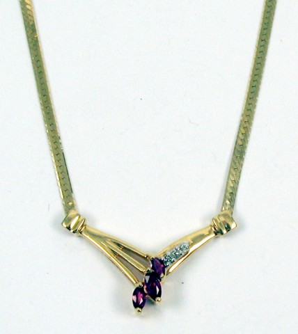 Appraisal: GARNET AND DIAMOND PENDANT NECKLACE the V-shaped pendant is suspended