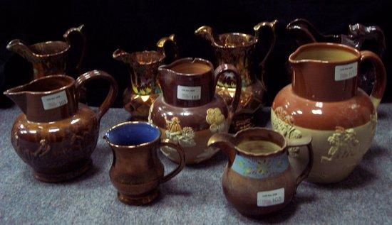 Appraisal: A graduated set of three copper lustre jugs highlighted with