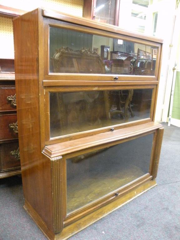 Appraisal: A walnut bookcase with sliding glazed doors