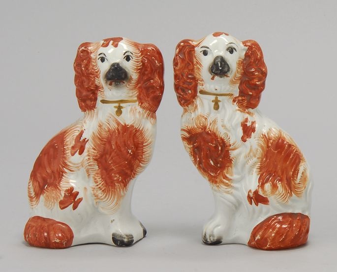 Appraisal: PAIR OF STAFFORDSHIRE FIGURES OF SPANIELS Circa In rust-red and