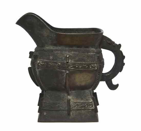 Appraisal: A Chinese Archaistic Style Bronze Pouring Vessel having a curved