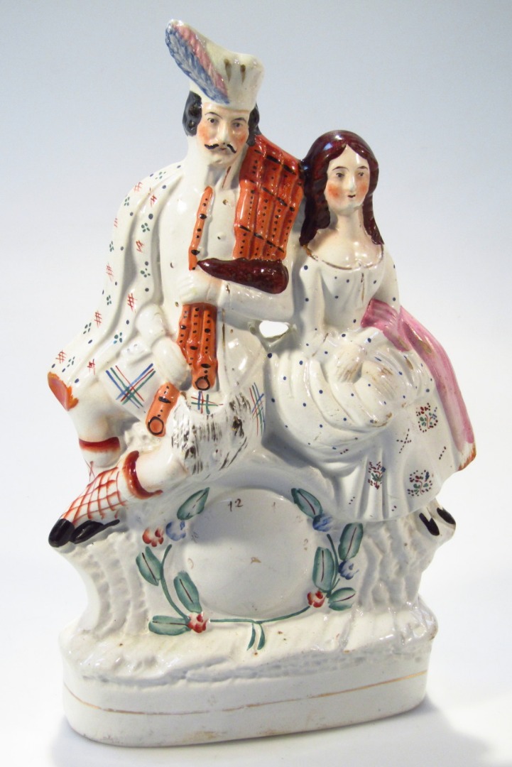 Appraisal: A thC Staffordshire pottery clock group formed as a highlander