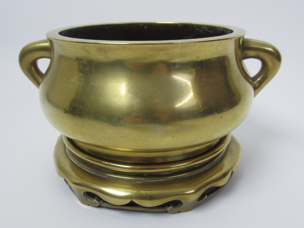 Appraisal: A Chinese bronze censer and bronze stand with curved handles