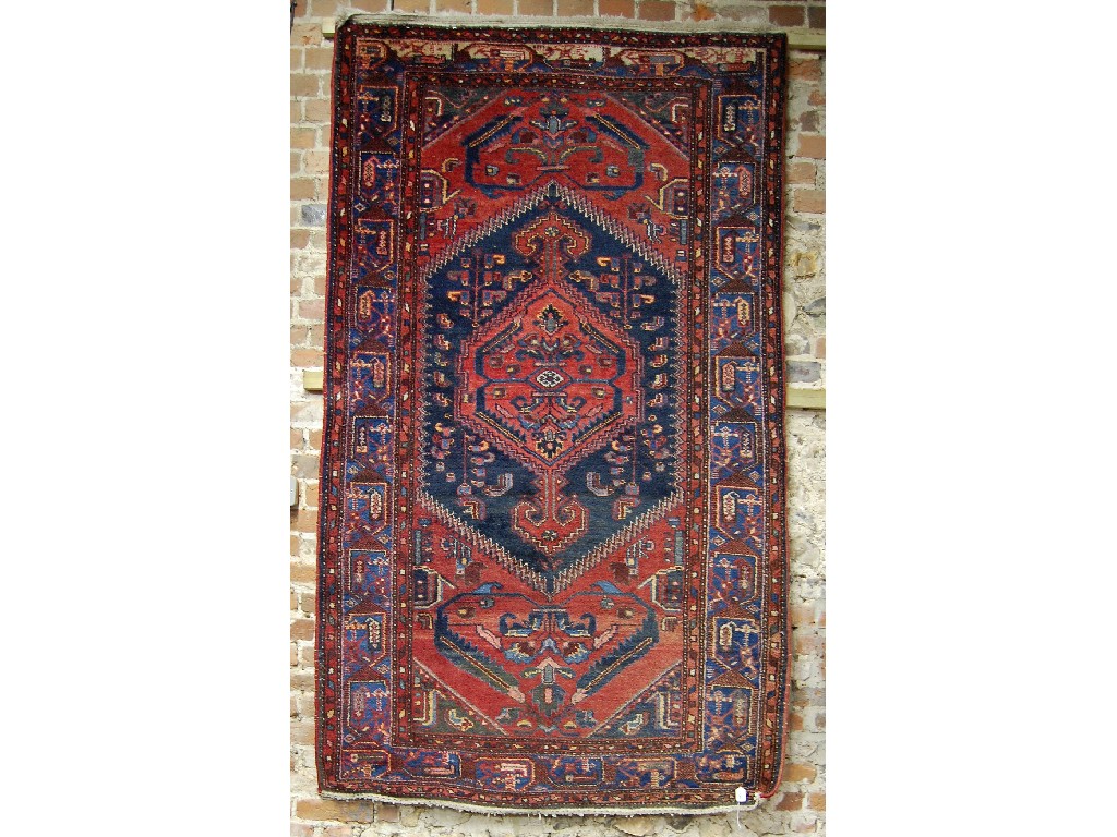 Appraisal: Caucasian red ground rug with floral design central lozenge with