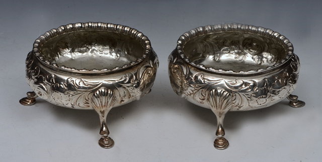 Appraisal: A PAIR OF VICTORIAN SILVER BUN SALTS with chased scroll