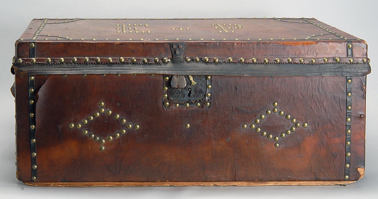 Appraisal: TH CENTURY LEATHER-BOUND STORAGE TRUNK embellished with narrow leather strips