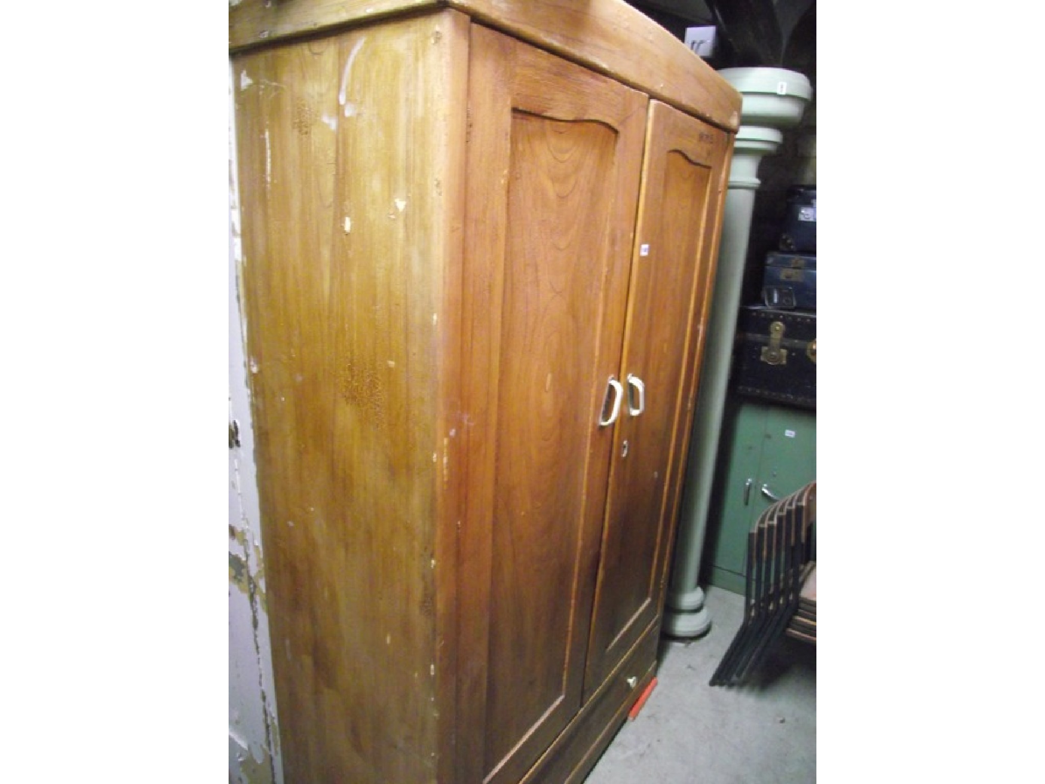 Appraisal: A vintage European pine wardrobe enclosed by a pair of