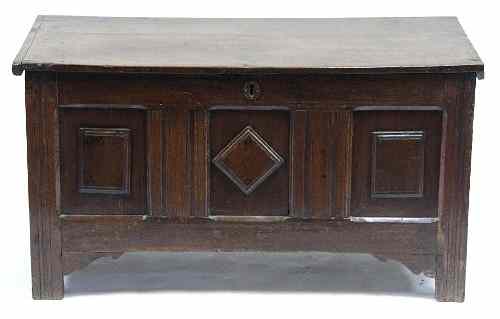 Appraisal: An oak chest with hinged cover and carved panel front