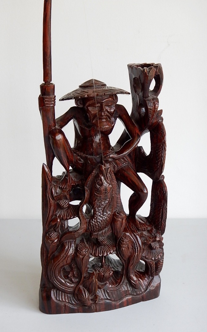 Appraisal: A Chinese carved hardwood figure of a fisherman in crouching