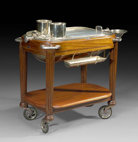 Appraisal: A mahogany and silver plated rolling trolley The hinged domed