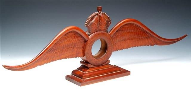 Appraisal: A CARVED MAHOGANY RAF EMBLEM with turned centre and carved