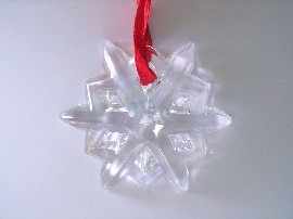 Appraisal: A crystal snowflake shaped ornament on a red ribbon by