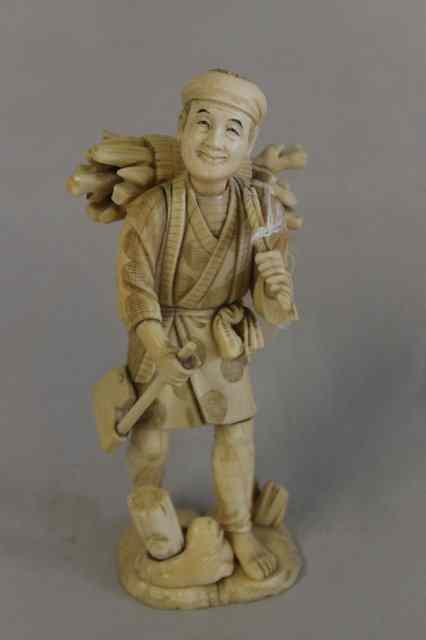 Appraisal: A JAPANESE IVORY FIGURE OF A WOOD GATHERER the old