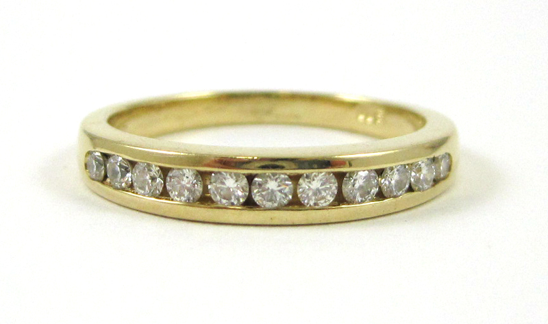 Appraisal: DIAMOND AND FOURTEEN KARAT GOLD RING channel set with eleven