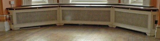 Appraisal: A triple pierced cast radiator surround with wooden top on