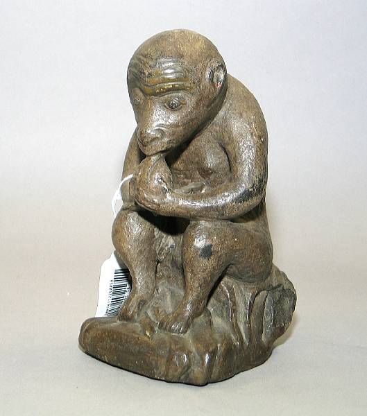 Appraisal: A carved grey stone model of a monkey eating a