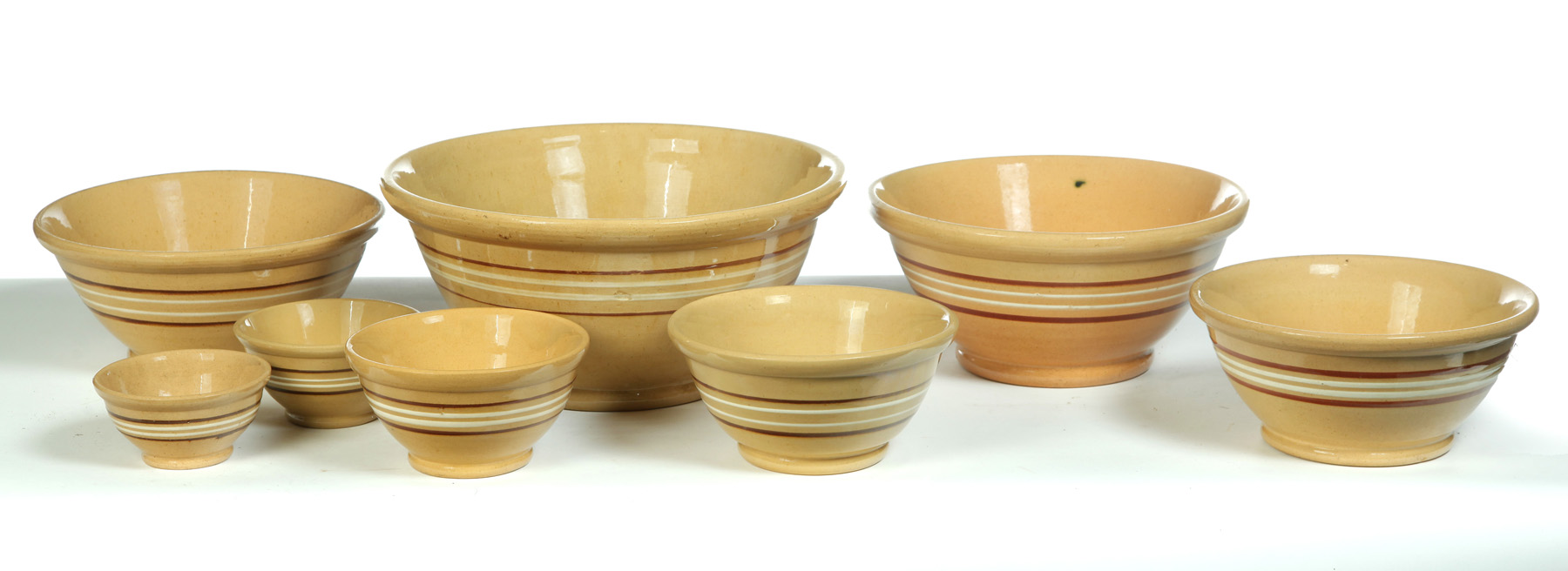 Appraisal: SET OF EIGHT NESTING YELLOWWARE BOWLS WITH BROWN AND WHITE