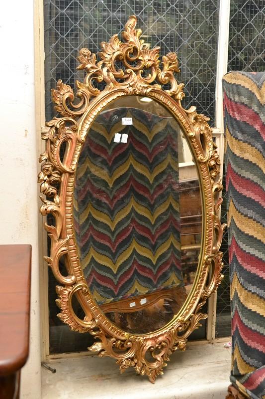 Appraisal: A GILT OVAL FRAMED WALL MIRROR A GILT OVAL FRAMED