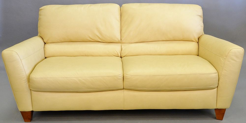 Appraisal: Leather sofa two seats pale yellow leather along with pair