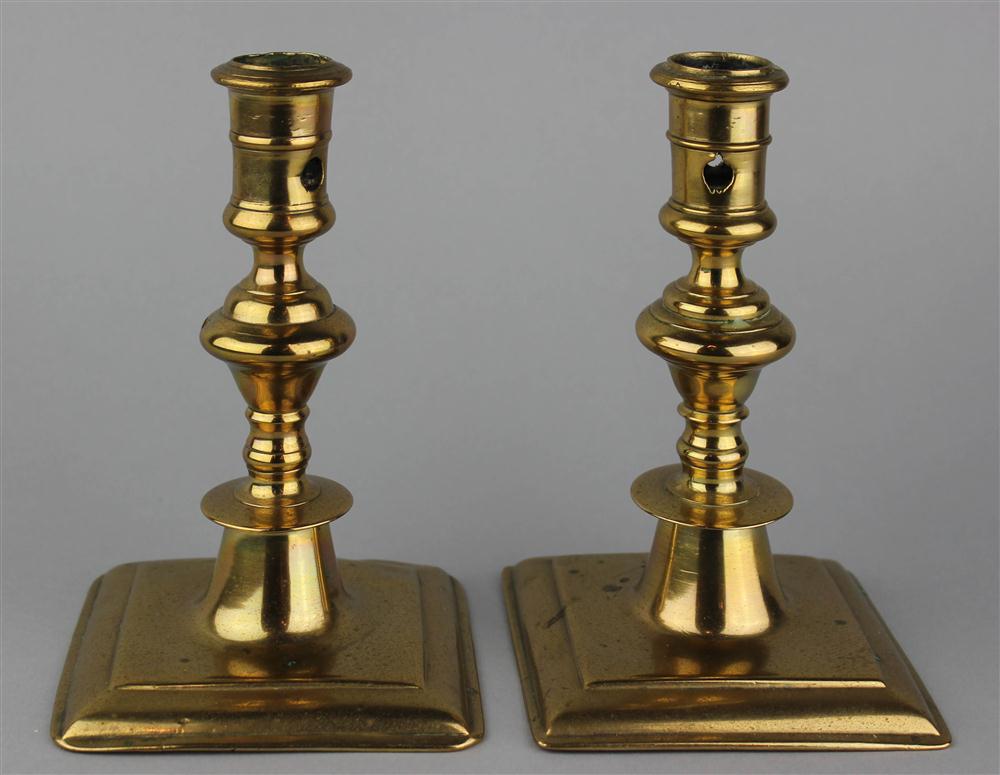 Appraisal: TWO CONTINENTAL BRASS SQUARE BASED CANDLESTICKS ca with two round