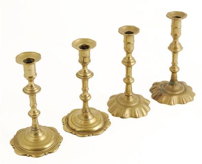 Appraisal: A pair of George III brass candlesticks raised on scallop