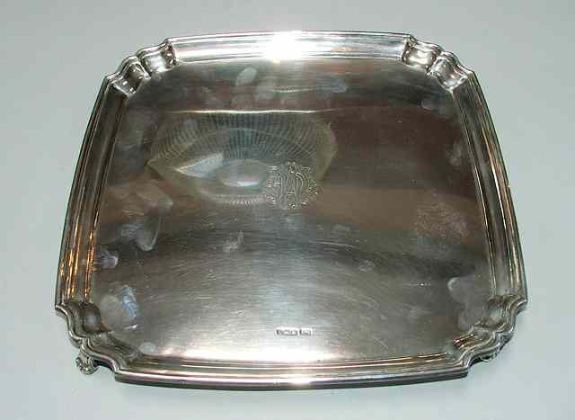 Appraisal: A SQUARE SILVER SALVER with shaped corners and four scroll