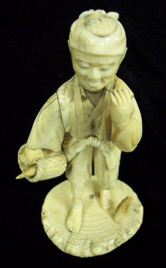 Appraisal: A Japanese carved ivory figure of a man holding a