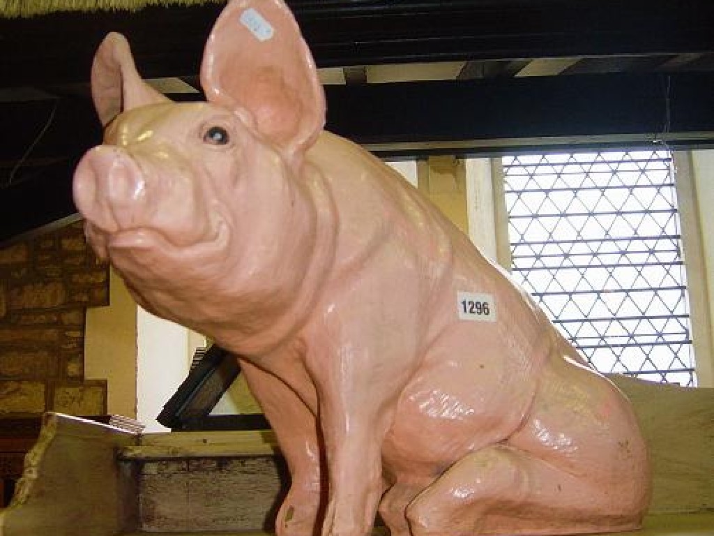 Appraisal: A moulded fibreglass model of a seated pig with painted