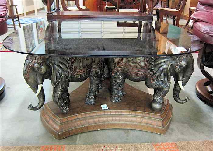 Appraisal: FIGURAL GLASS-TOP COFFEE TABLE featuring three cast elephants standing on