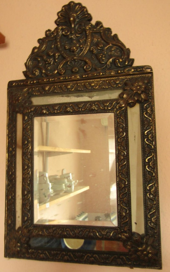 Appraisal: A thC cushion mirror with embossed brass frame and bevel