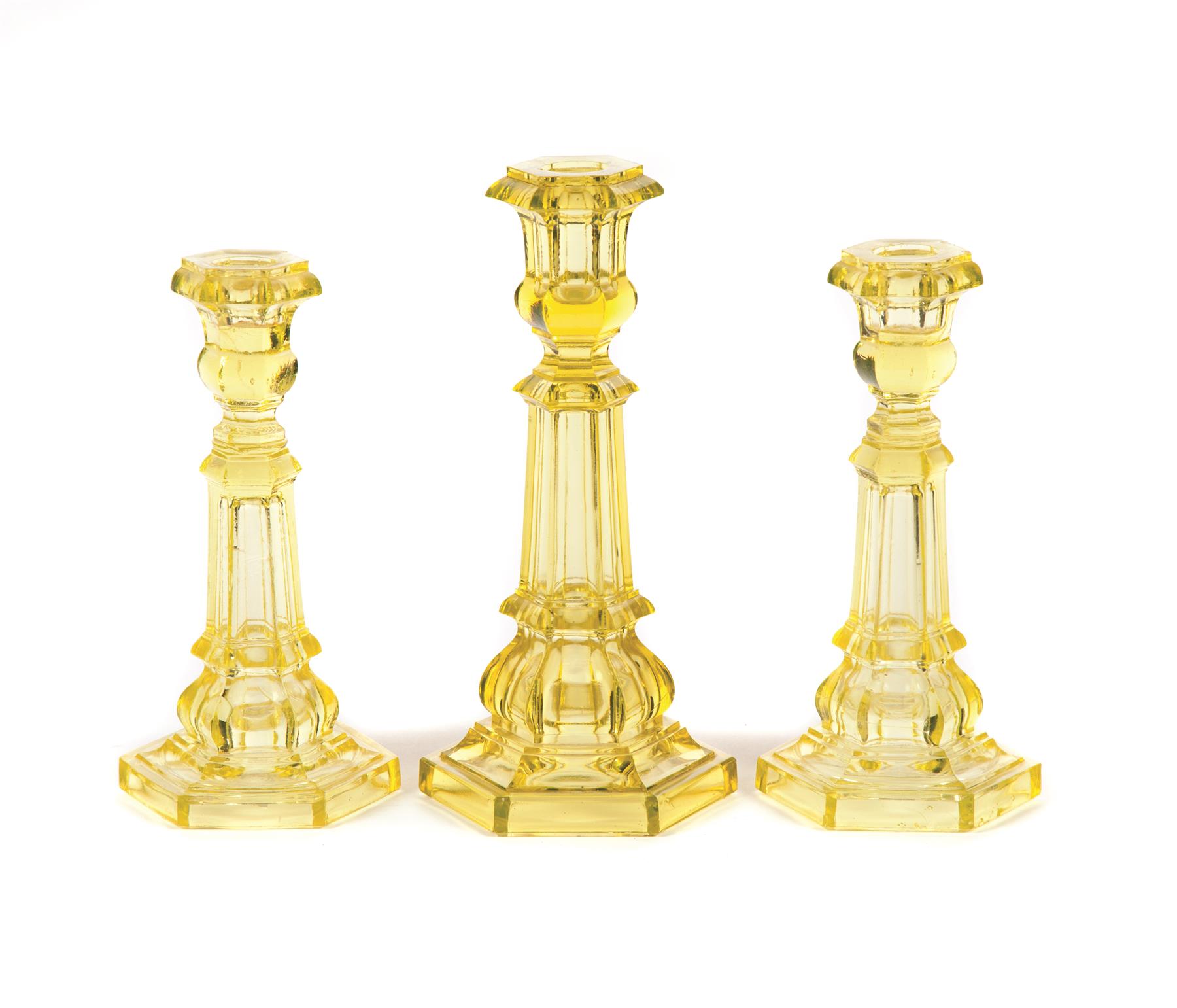 Appraisal: THREE PITTSBURGH CANARY CANDLESTICKS American mid th century Hexagonal paneled