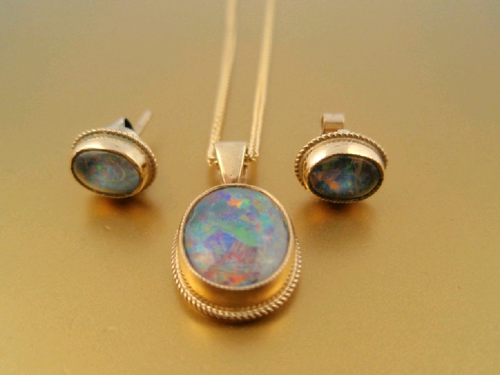 Appraisal: An oval cabachon opal pendant and matching earrings stamped