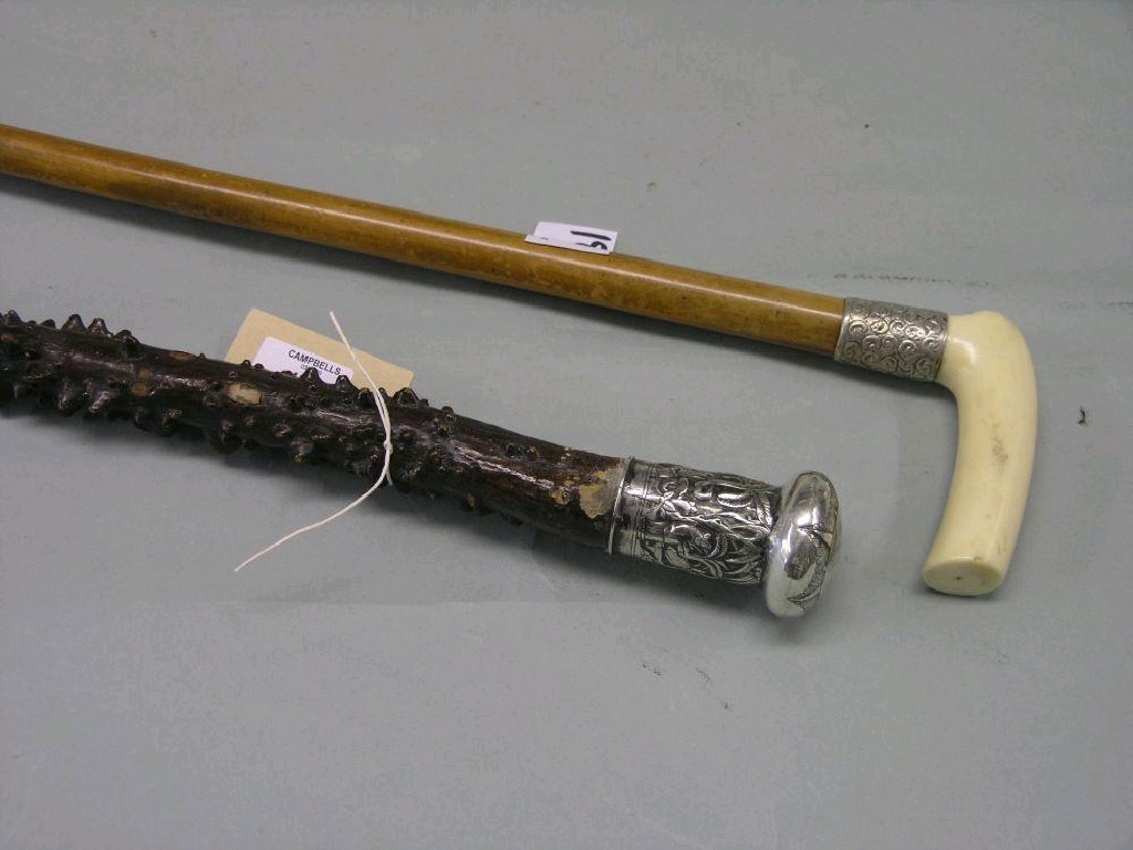 Appraisal: A malacca walking stick with ivory handle and embossed silver