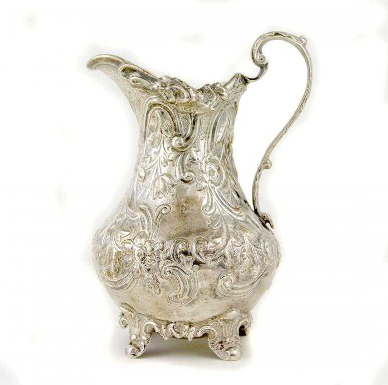 Appraisal: A VICTORIAN CREAM JUG of baluster shape chased with flowers