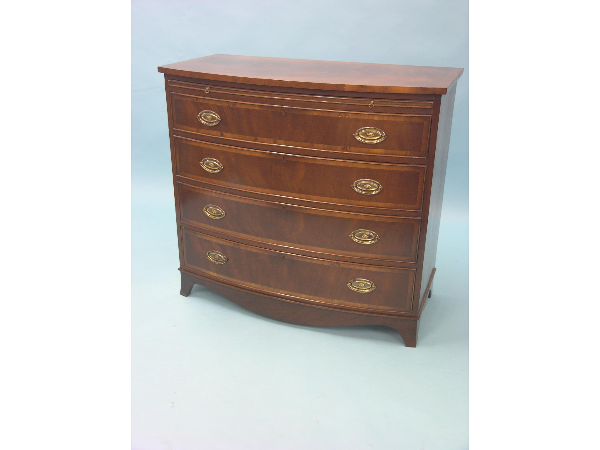 Appraisal: A reproduction mahogany chest bow-fronted brushing slide above four long