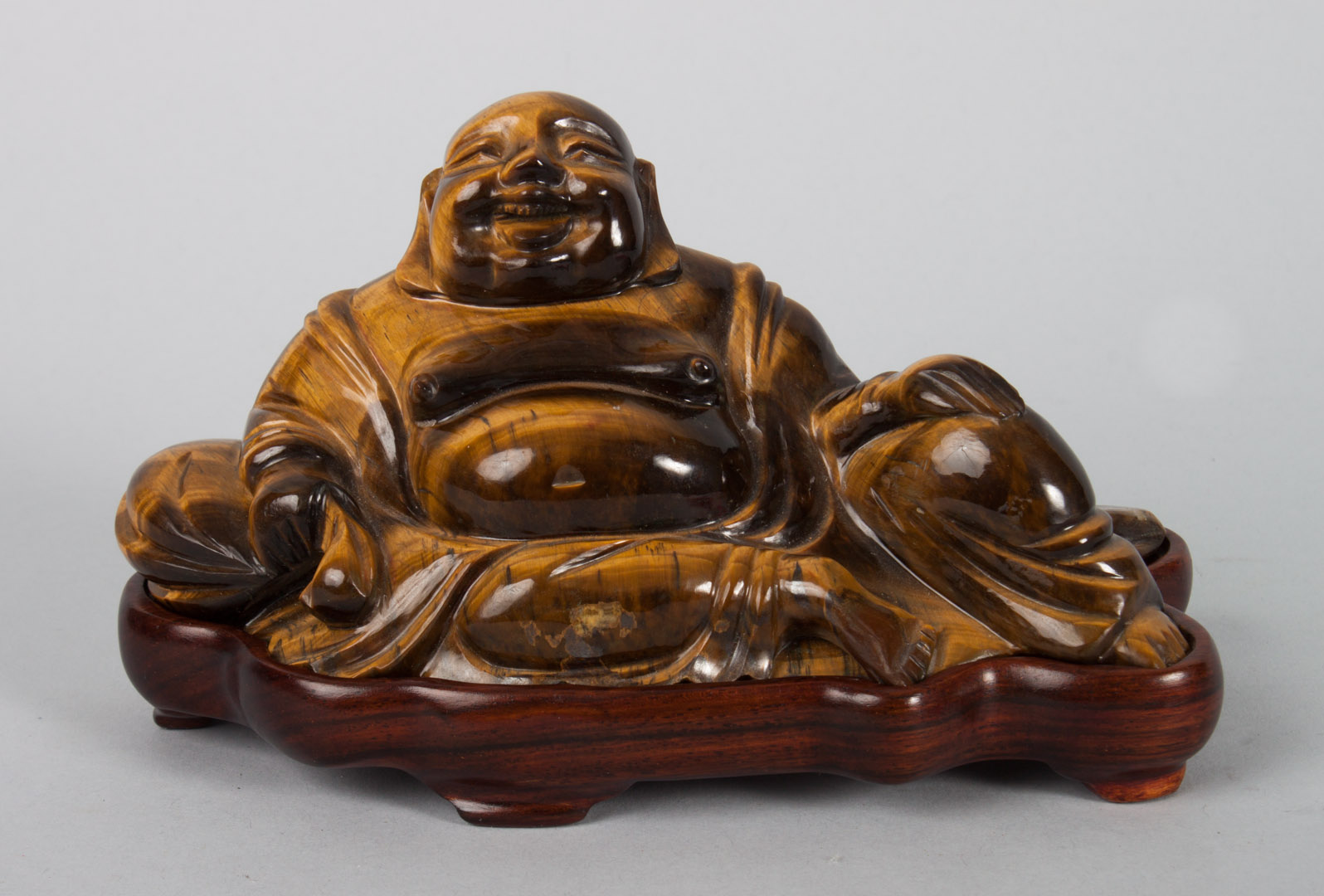 Appraisal: Chinese carved tiger's-eye Hotai figure in reclining position with sack