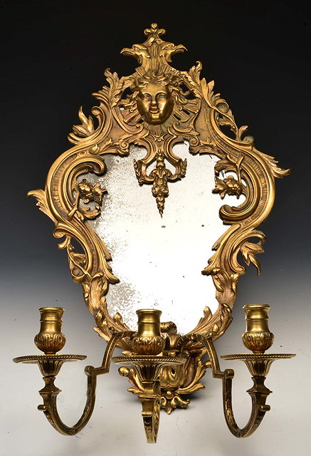 Appraisal: A FRENCH GILT BRASS GIRANDOLE MIRROR with three scroll candle