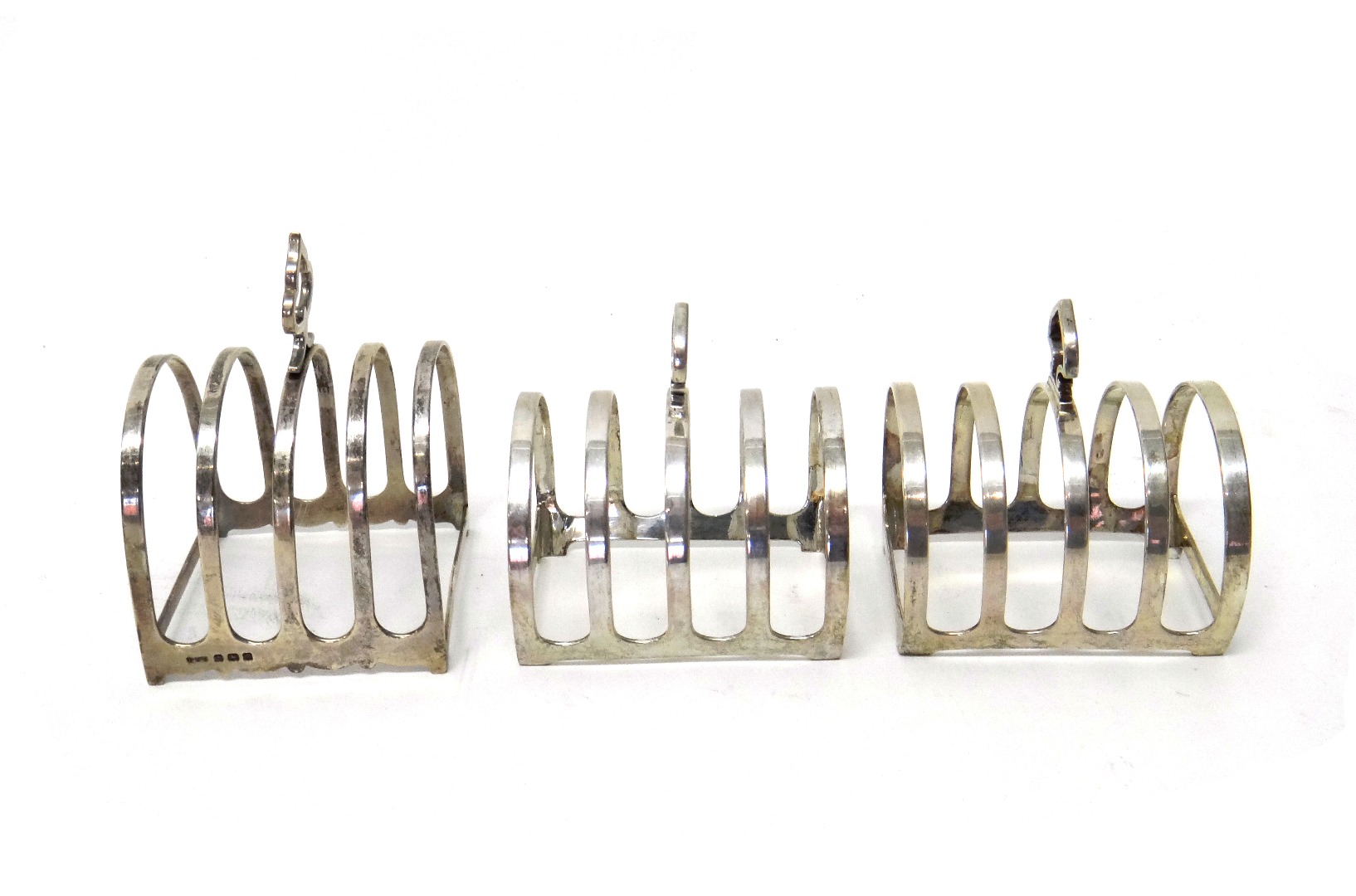 Appraisal: A pair of silver five bar toastracks with loop shaped