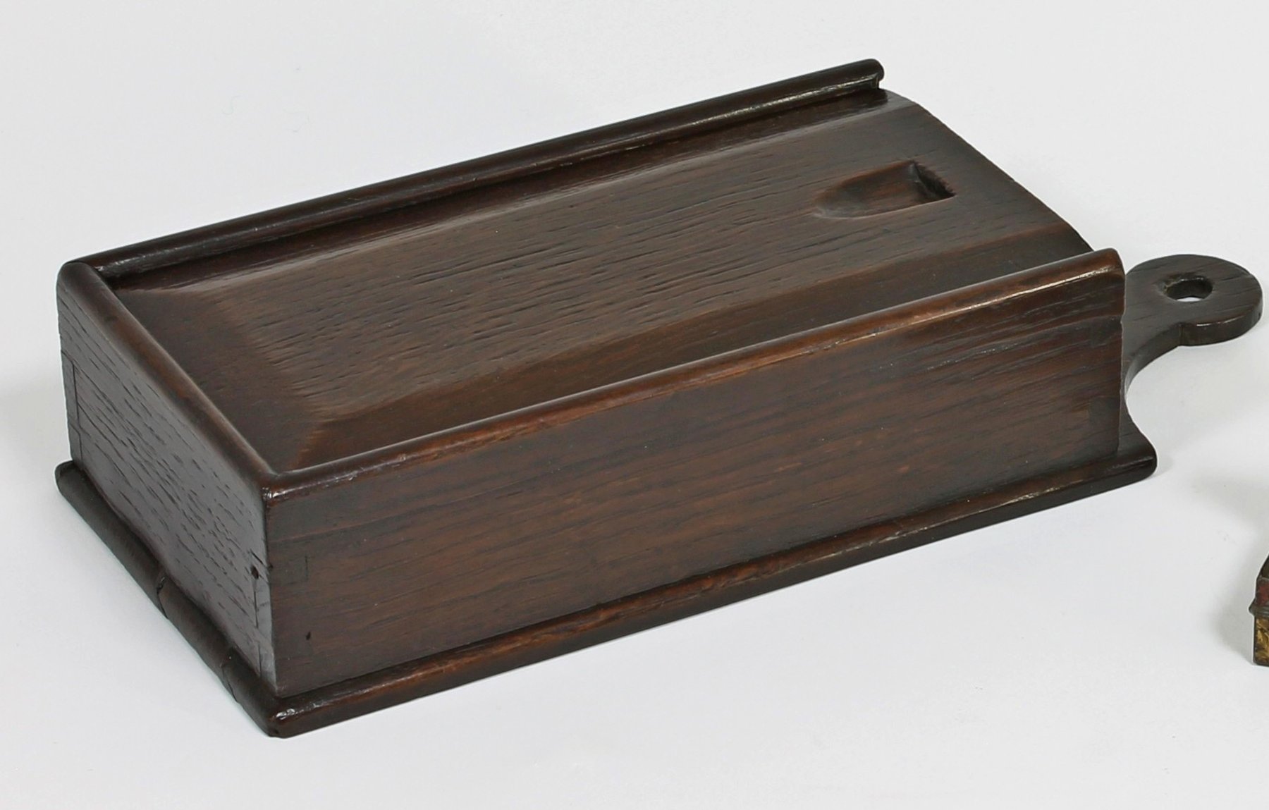 Appraisal: An oak tinder box with bevelled sliding lid and hanging