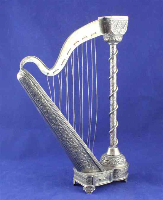 Appraisal: An Indian white metal novelty candlestick modelled as a harp