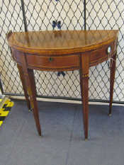 Appraisal: An antique mahogany demi lune side table with drawer on