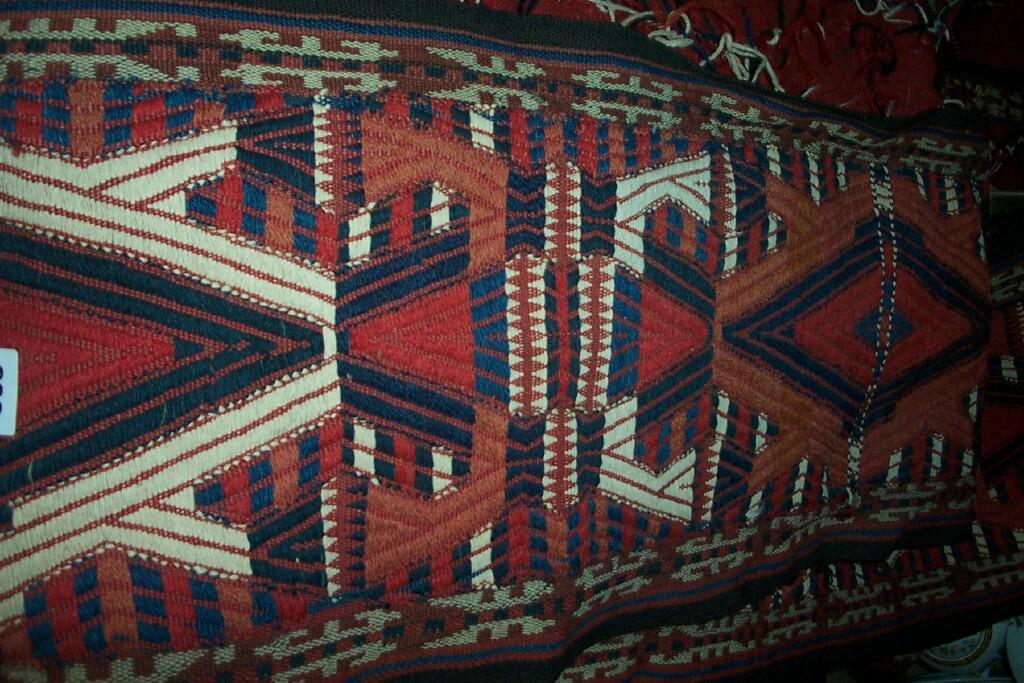 Appraisal: A long Eastern wool panel with geometric decoration in red