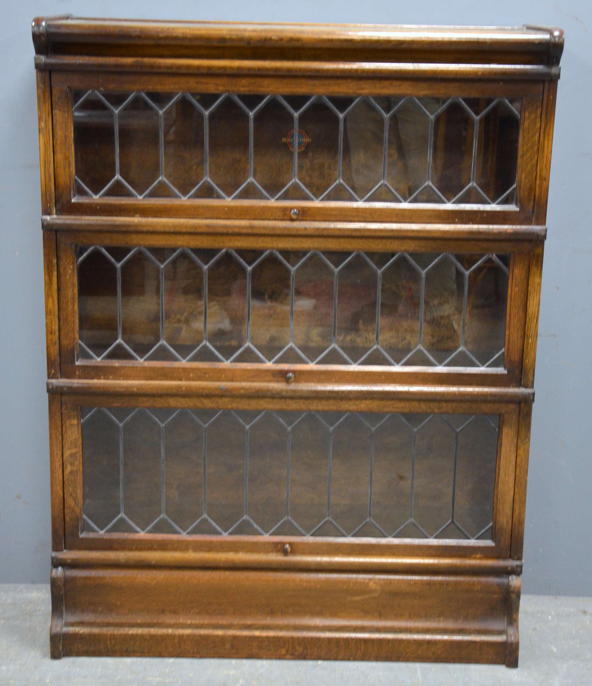 Appraisal: An oak three section lead glazed Globe-Wernicke book case