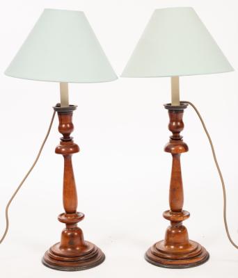 Appraisal: A pair of turned fruitwood candlesticks with metal drip trays