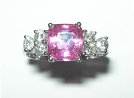 Appraisal: A modern pink sapphire and diamond set ring with central