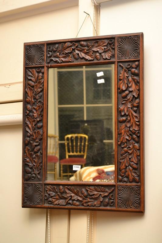 Appraisal: A DECORATIVELY CARVED TIMBER WALL MIRROR A DECORATIVELY CARVED TIMBER